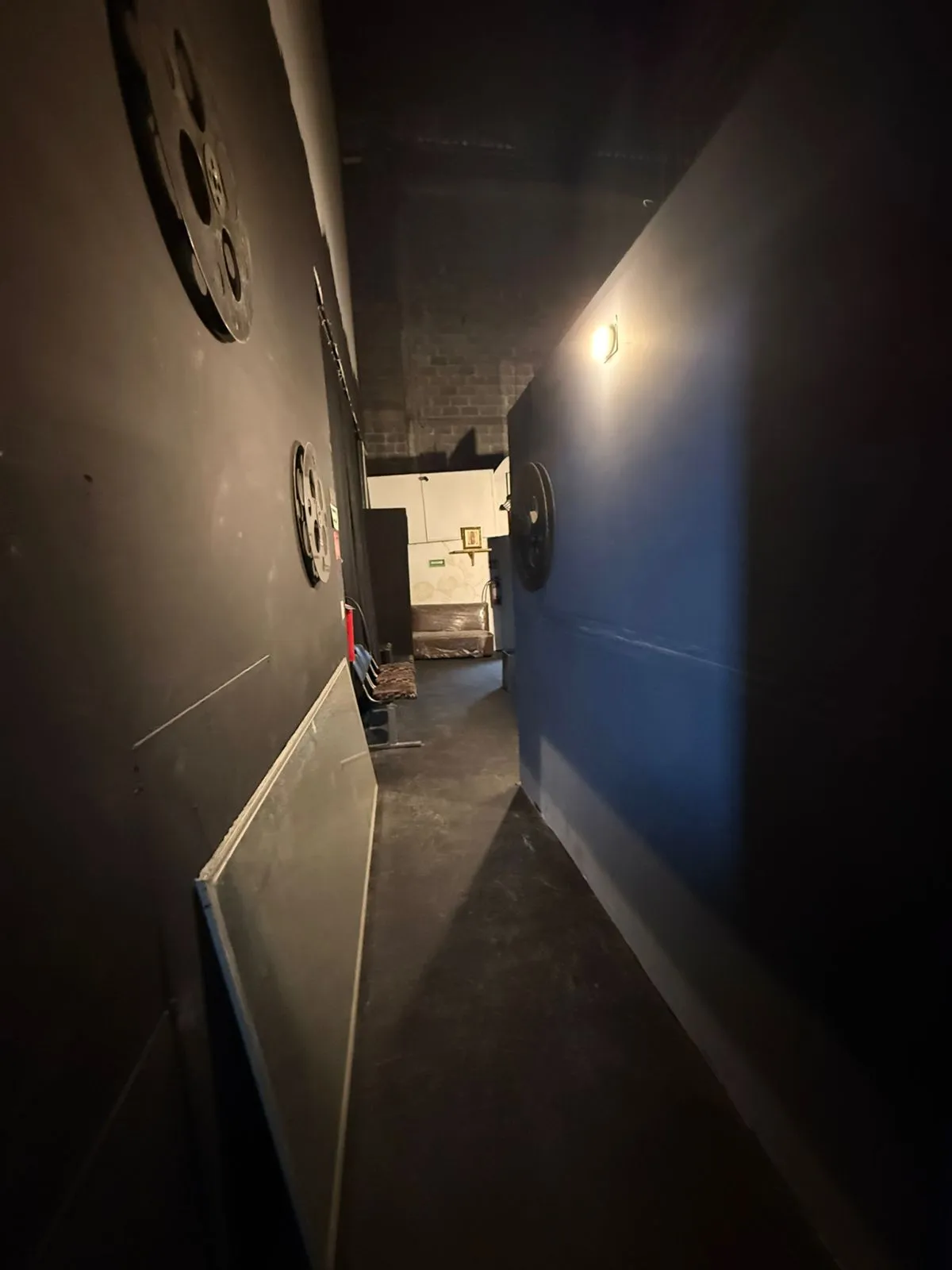 Pasillo de servicio tras bambalinas en el Teatro Balderas, decorado con rollos de película.