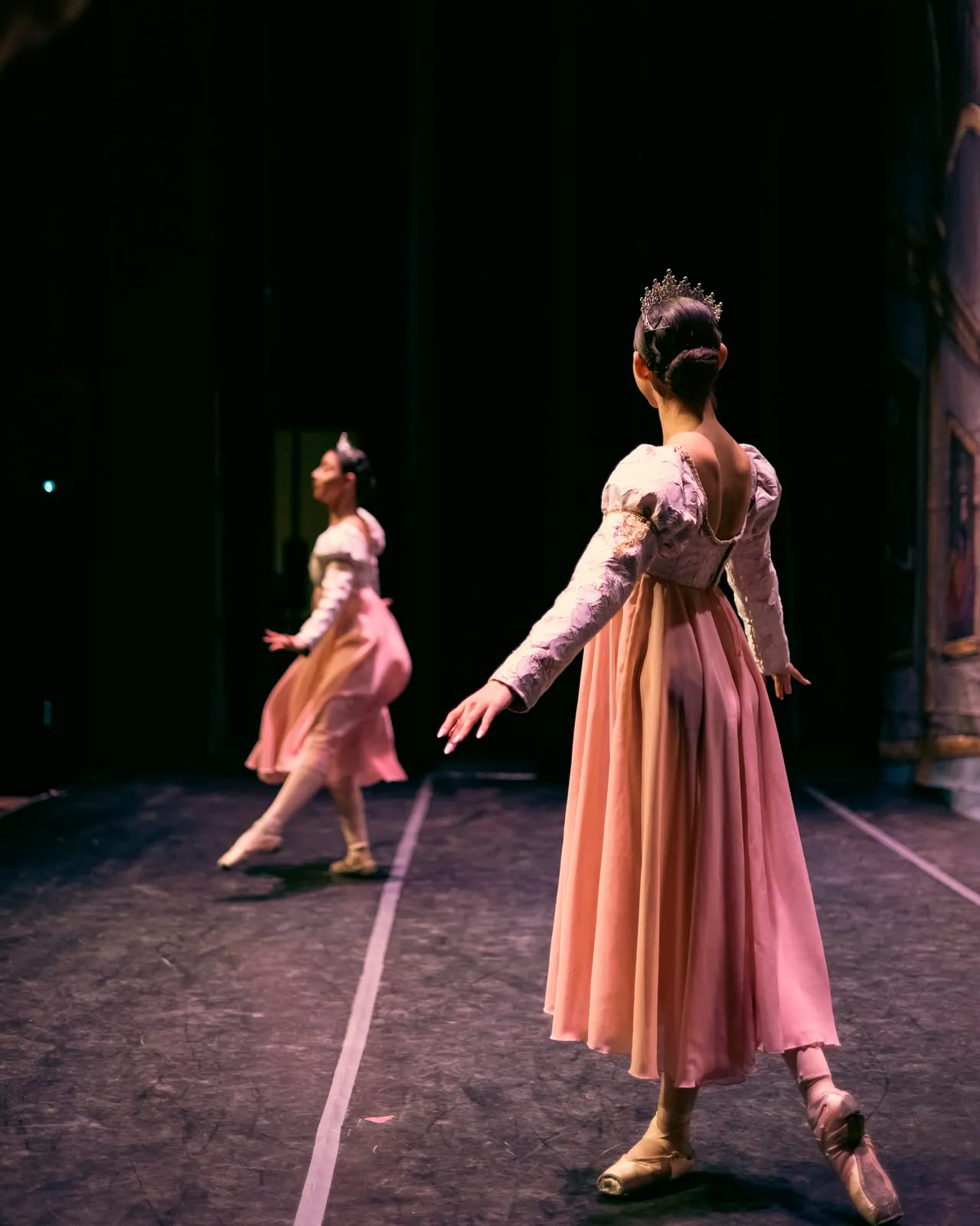 Dos bailarinas con vestido rosa vistas desde el backstage durante la función.