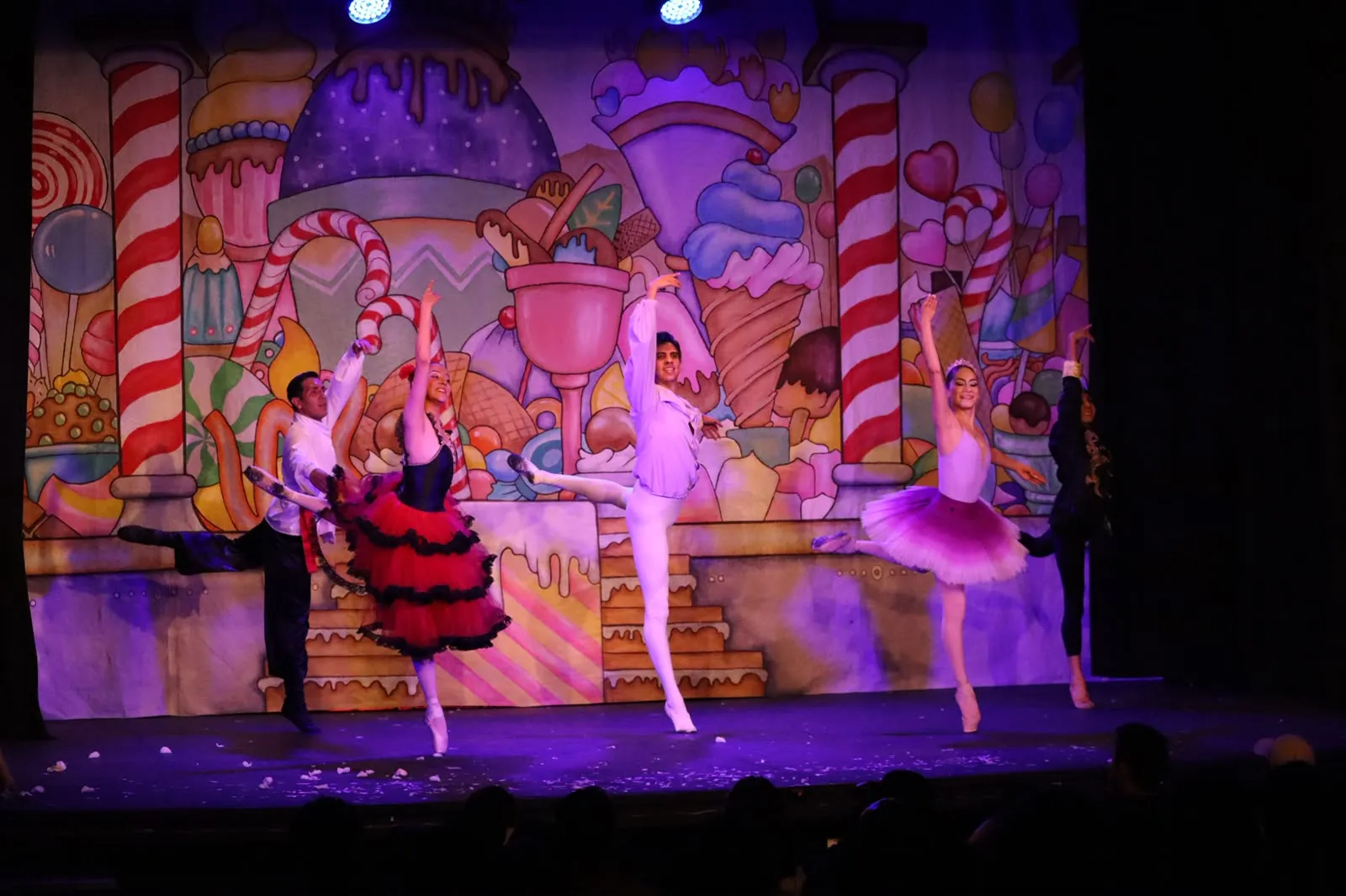 Bailarines de El Cascanueces frente al telón del reino de los dulces.
