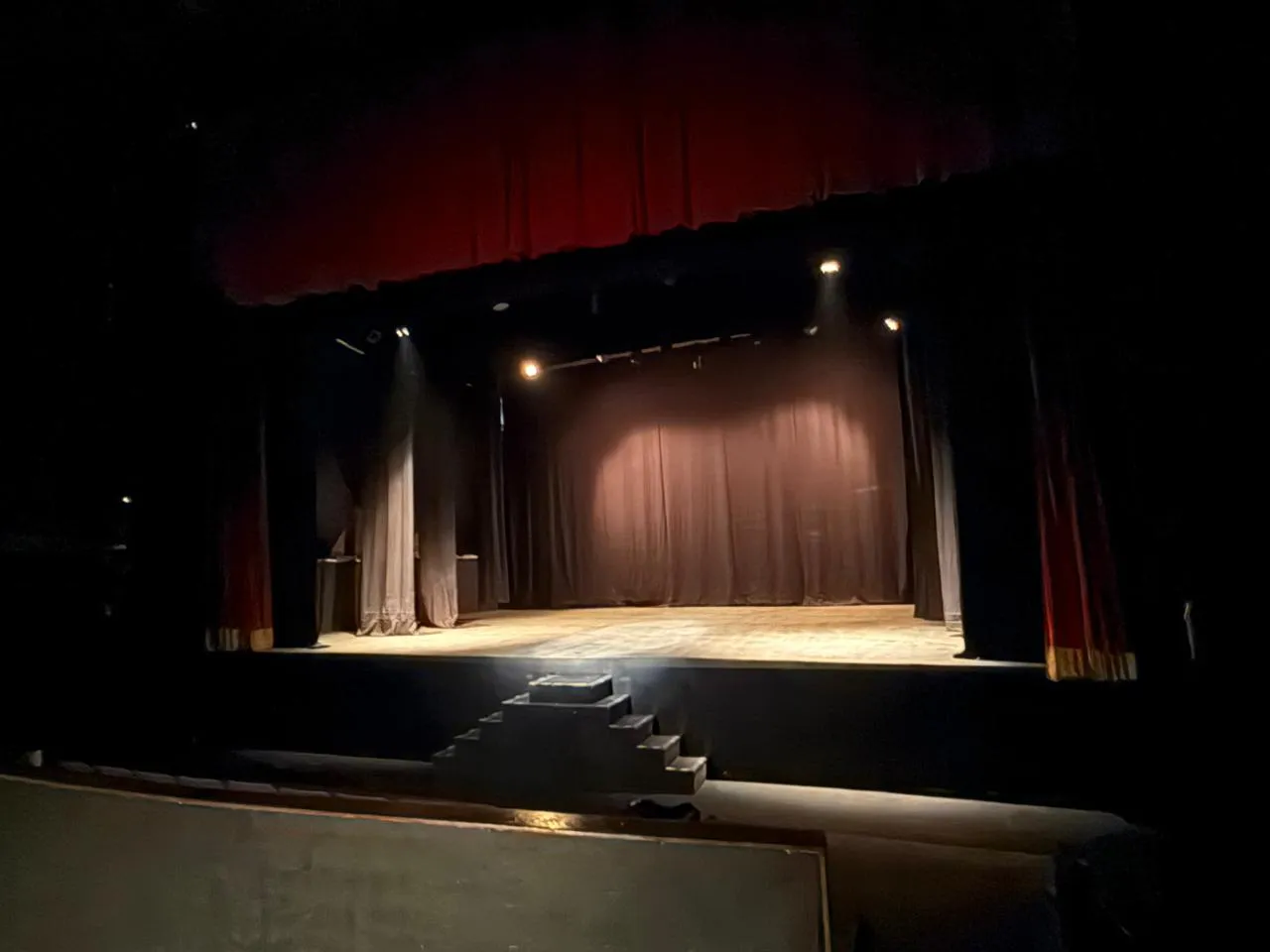 Escenario del Teatro Balderas visto desde la sala, con escalinata de acceso y telones para montaje.