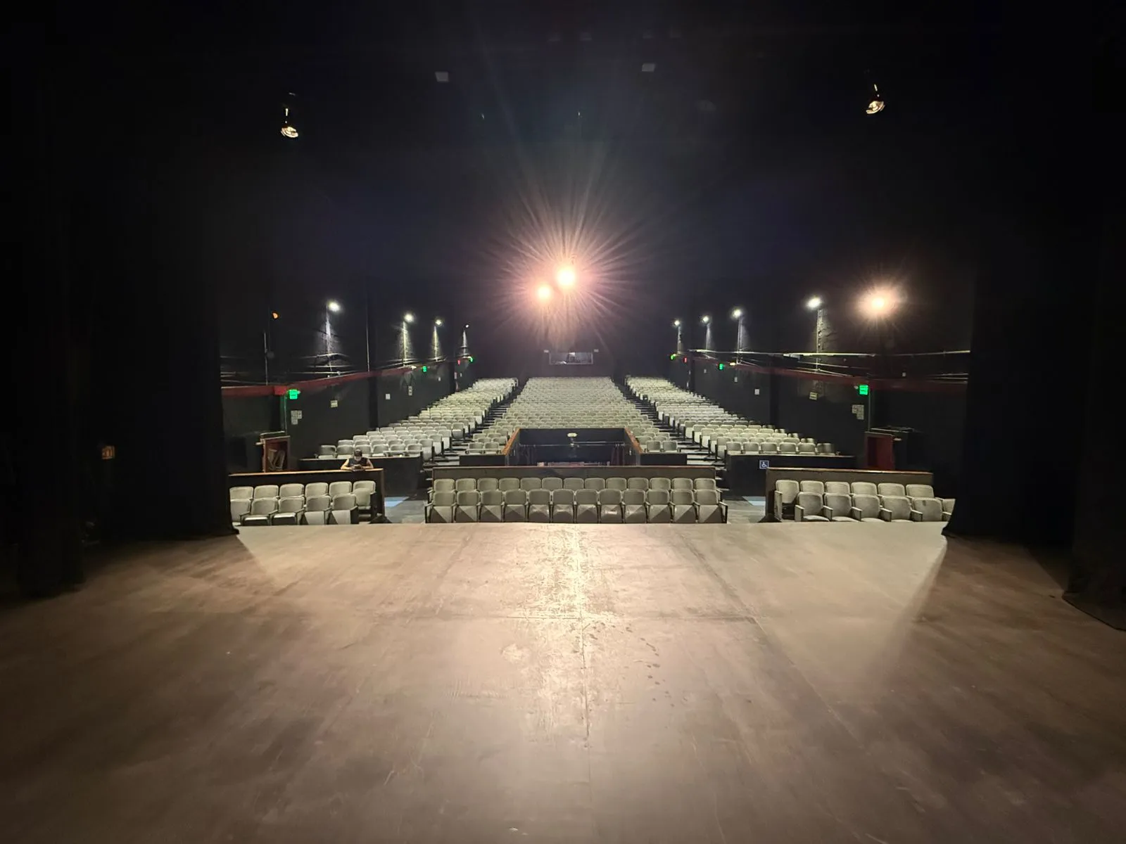 Vista de la sala del Teatro Balderas desde el escenario: gradería completa de butacas iluminada.
