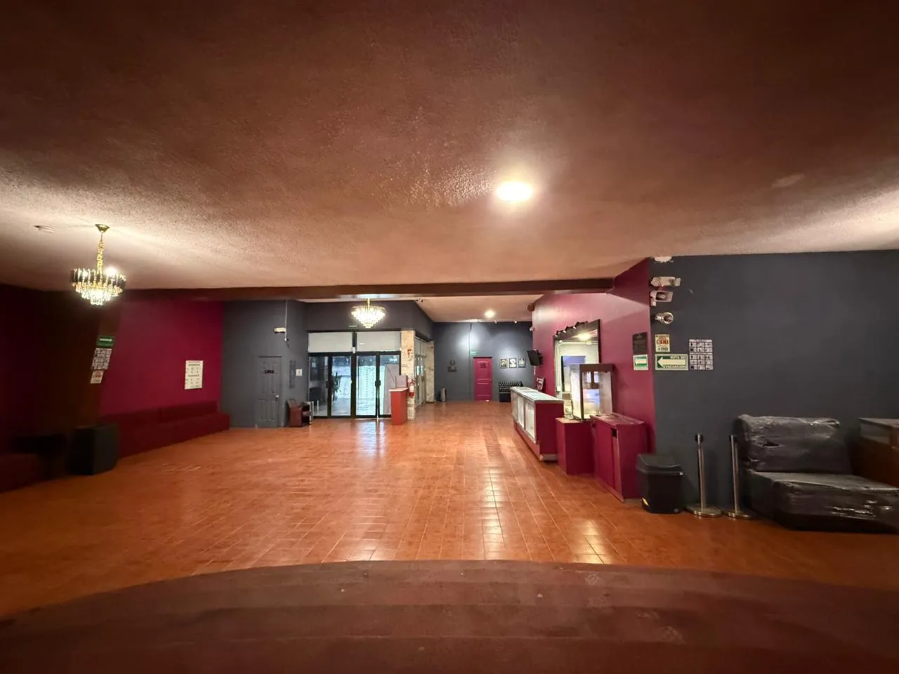 Amplio vestíbulo del Teatro Balderas iluminado por candiles, con dulcería y salas de espera.