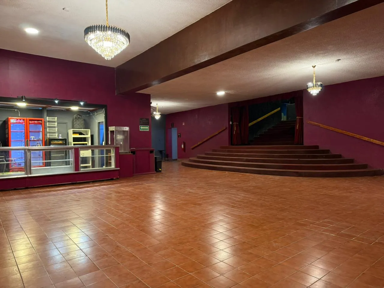 Vestíbulo del Teatro Balderas con candiles, dulcería y escalinata alfombrada de acceso a la sala.